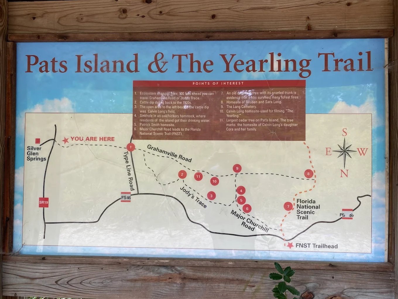 Trailhead interpretive sign for Pats Island and the Yearling Trail, showing a map of eleven numbered points of interest including the Long Cemetery, old homestead sites, and a sinkhole in the oak/hickory hammock.